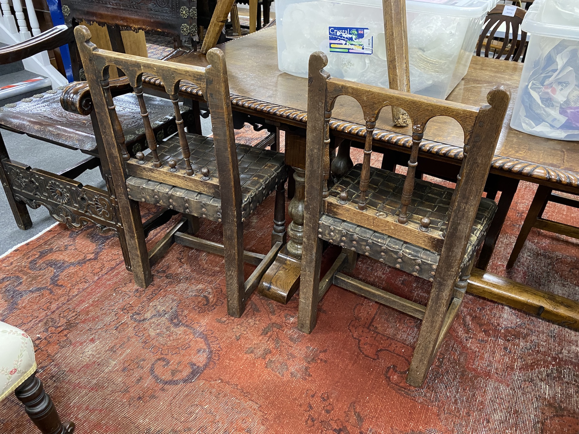 A set of four spindle back dining chairs with leather strapwork seats